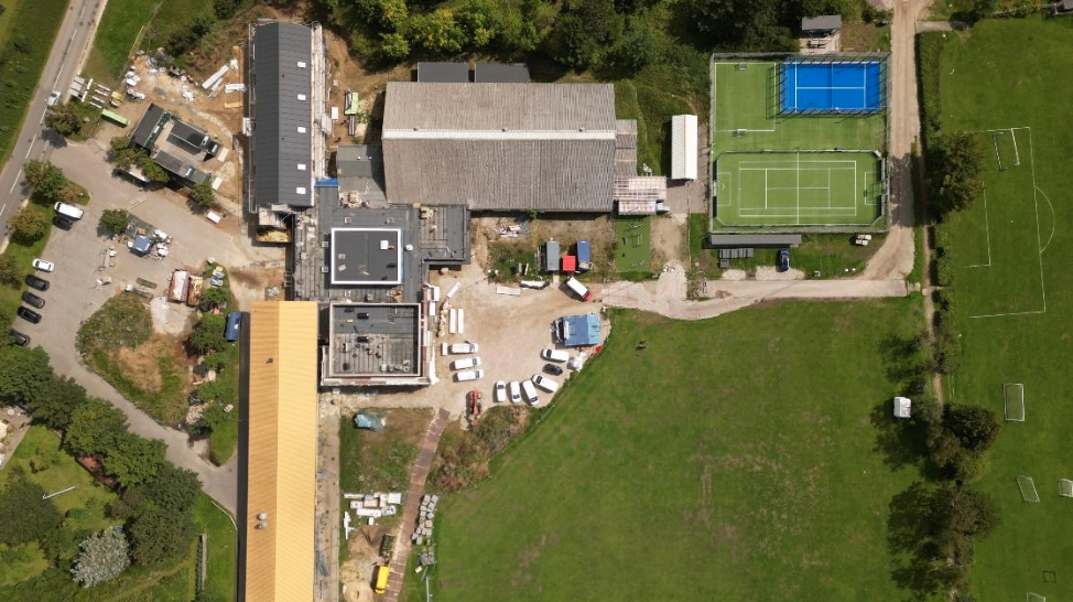 Foto taget i fugleperspektiv (fra 2. august 2023). Børnehuset ses øverst tv. Derefter Molshallen og det nye multibane og padel-anlæg.